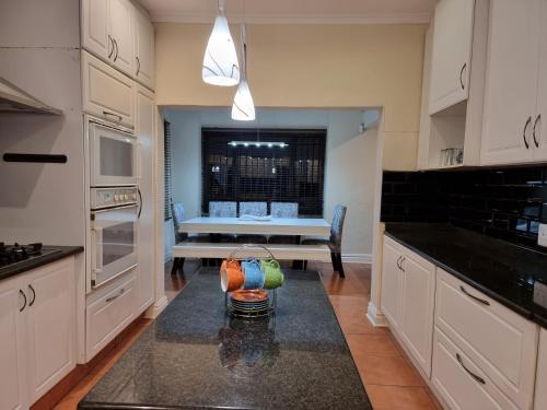 a kitchen with a table with a vase on a counter at 11-on-RobRoy calming space with 3 bedrooms&pool in Hillcrest