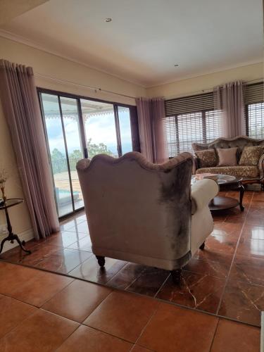a living room with a couch and a chair at 11-on-RobRoy calming space with 3 bedrooms&pool in Hillcrest