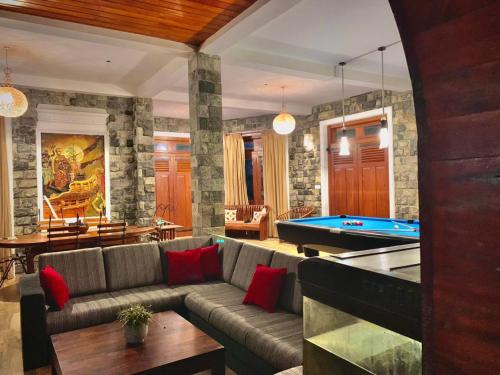 a living room with a couch and a pool table at Diyon Bungalow in Bandarawela