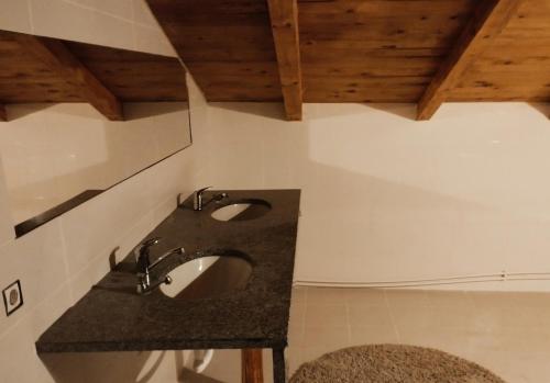 a bathroom with two sinks and wooden ceilings at Cabana Kraus in Valea Vişeului