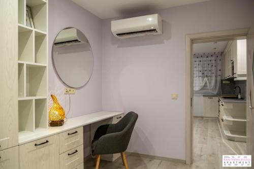 a room with a mirror and a desk and a chair at Rose Valley Aroma Apartment in Kazanlŭk