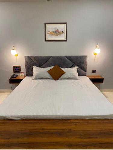 a bedroom with a large white bed with two tables at Hotel Green Park in Korba