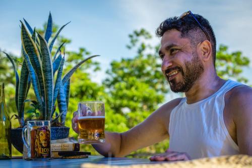 a man sitting at a table with a glass of beer at Atrium Hiriketiya in Hiriketiya
