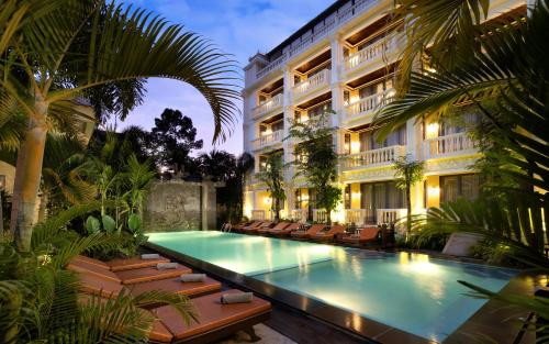 um hotel com piscina em frente a um edifício em The Elephant em Siem Reap