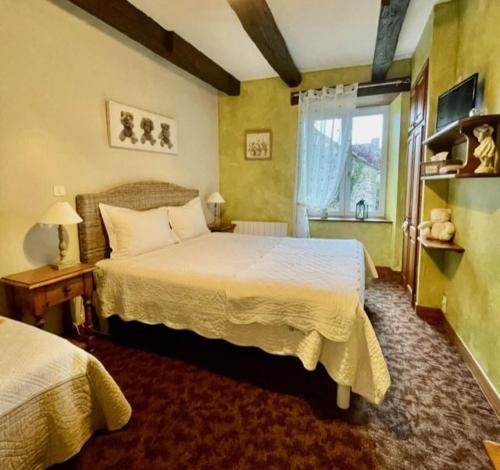 1 dormitorio con 2 camas y ventana en Le couvent de Jouels, en Sauveterre-de-Rouergue
