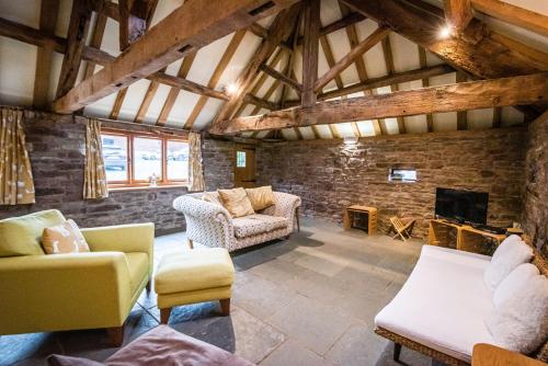 ein Wohnzimmer mit Sofas und einem Kamin in der Unterkunft Pomona Cottage at Old King Street Llama Farm in Ewyas Harold