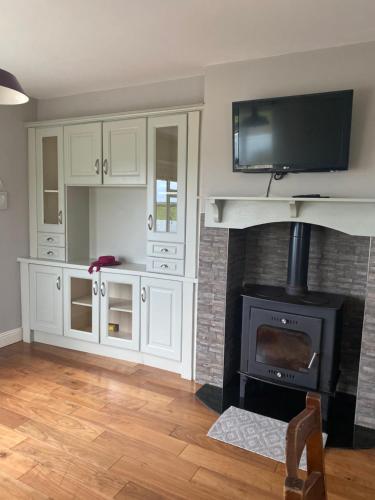 a living room with a fireplace with a tv above it at Private House, Wild Atlantic Way, Spanish Point Road, Miltown Malbay in Miltown Malbay
