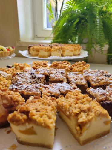 a pile of desserts sitting on top of a table at Bohema Restauracja i Noclegi in Supraśl