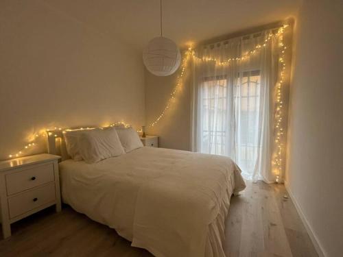 Un dormitorio con una cama con luces. en Precioso Bajo en 2a línea de mar, en Segur de Calafell