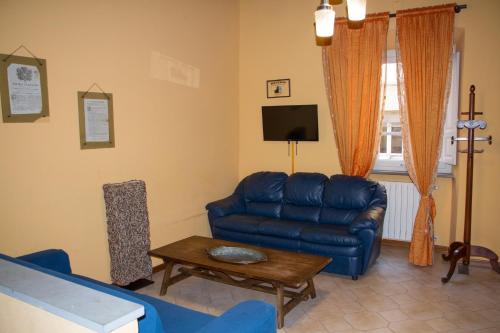 ein Wohnzimmer mit einem blauen Sofa und einem Tisch in der Unterkunft Appartamento Porta Crucifera in Arezzo