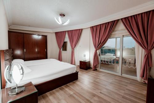 a bedroom with a large white bed and a balcony at Luxury private villa with pool in Hurghada