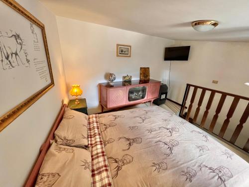 a small room with a bed and a tv at I Due Gradoni Stone House in Pacentro