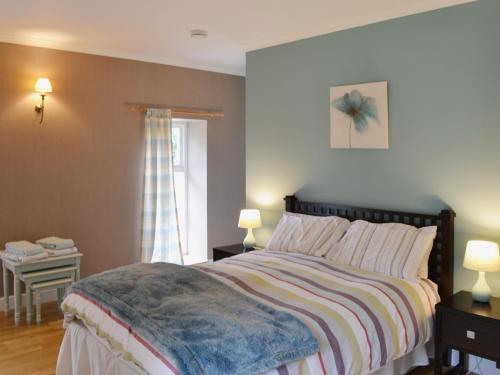 a bedroom with a large bed and a window at The Kennels Bothy - Beaufort Estate in Belladrum