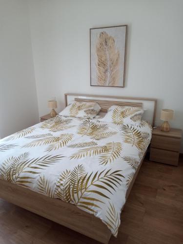 een slaapkamer met een bed met een wit dekbed bij MON PETIT COIN DE PARADIS in Puyoô