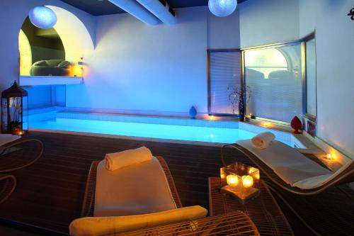 a room with a pool with two chairs and a table at Quintocanto Hotel & Spa in Palermo