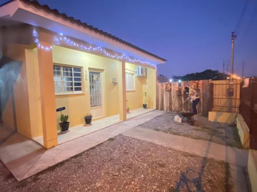 uma pequena casa amarela com uma cerca em frente em Cantinho Dom Inácio em São Gabriel