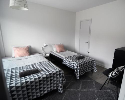 um quarto com duas camas e uma cadeira. em Scandinavian Home 17 city Center Työmiehenkatu 2B em Helsínquia