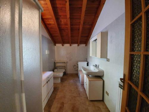 uma casa de banho com um lavatório e um WC em Pleasant apartment in Vendrogno with balcony em Regoledo