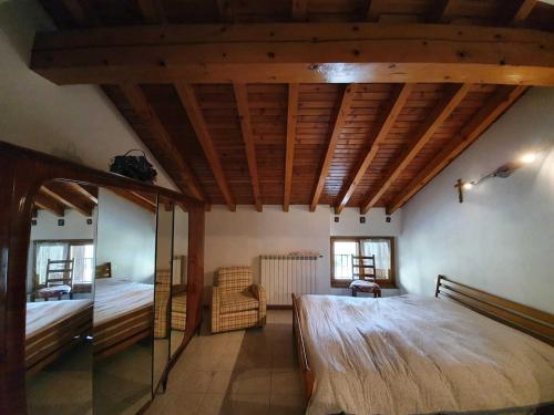 um quarto com uma cama grande e um tecto em madeira em Pleasant apartment in Vendrogno with balcony em Regoledo