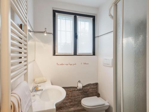 a bathroom with a sink and a toilet and a window at Stagno Lombardo Garden Flat in Stagno Lombardo