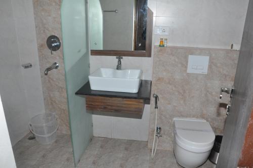 uma casa de banho com um lavatório e um WC em Pramod Convention & Beach Resorts em Puri