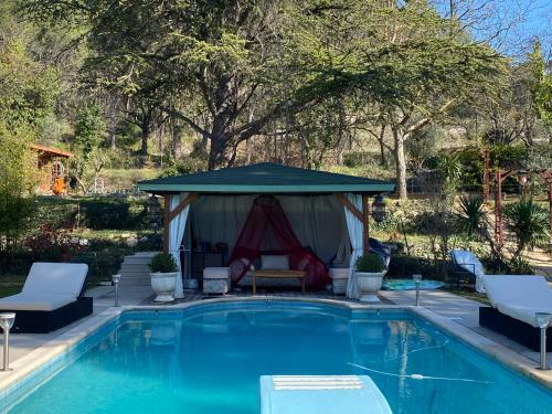 un gazebo à côté d'une piscine dans l'établissement Maison + piscine à 10 min d'Aix en Pce, à Meyreuil