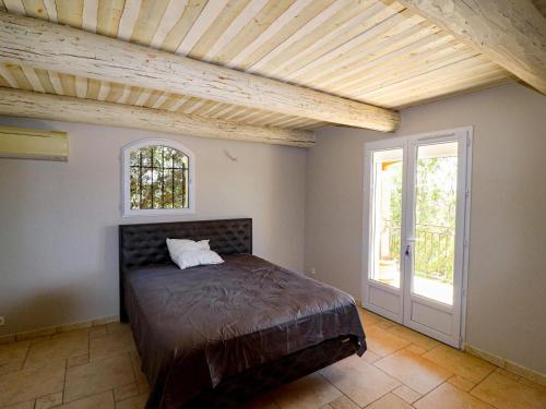 1 dormitorio con cama y techo de madera en Amazing holiday home in Flayosc with private pool, en Flayosc