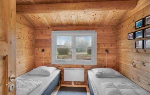 two beds in a wooden room with a window at Holiday Home Jacobslystvej Gilleleje Vi in Gilleleje