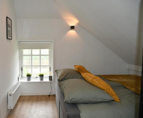 1 dormitorio con cama y ventana en Appartementen Chaamse Bossen met tuin, en Chaam