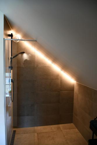 La salle de bains est pourvue d'une douche avec un éclairage LED. dans l'établissement Appartementen Chaamse Bossen met tuin, à Chaam