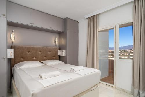 a bedroom with a white bed with a large window at Stella Maris apartment in Fuengirola Ref 36 in San Francisco