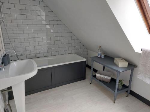 a bathroom with a sink and a bath tub at Les Gages in Brécé