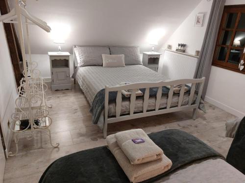 a bedroom with a bed with towels on it at Les Gages in Brécé