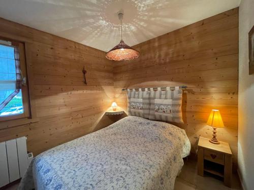 een slaapkamer met een bed in een houten muur bij Appartement Samoëns, 3 pièces, 7 personnes - FR-1-624-19 in Samoëns