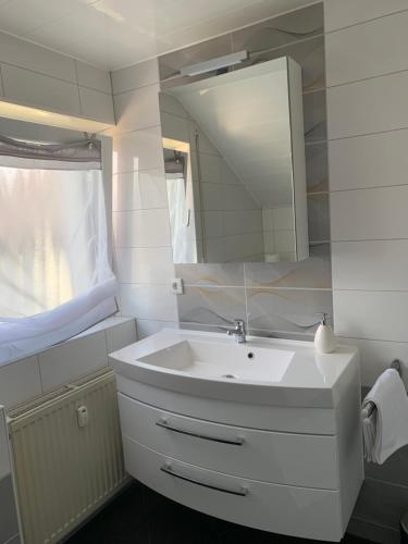 Obersulm2 Zimmer Ferienwohnung的浴室设有白色水槽和镜子