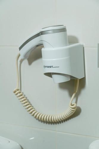 a phone hanging on a wall in a bathroom at Wonderland spa apartment in Niš