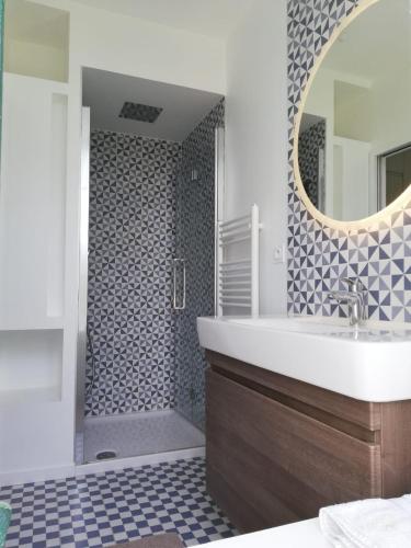 une salle de bain avec un lavabo et une douche avec un miroir dans l'établissement KER HUELLA - Superbe vue mer et accès plage privé, à Saint-Pabu