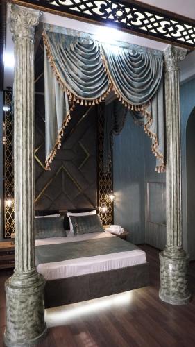 ein Schlafzimmer mit einem Himmelbett mit zwei Säulen in der Unterkunft Goldenlife Hotel Baku in Baku