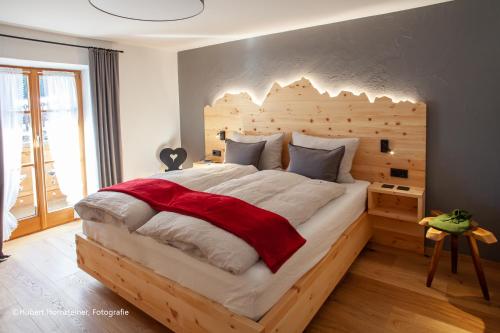 una camera con un grande letto con testiera in legno di das Alpen Natur Idyll a Grainau