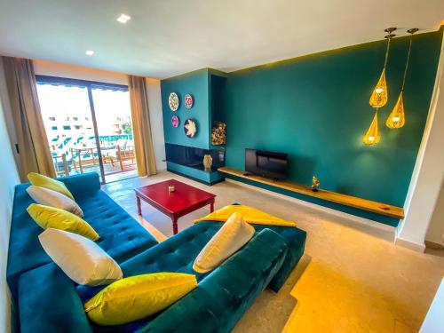 sala de estar con sofá azul y almohadas amarillas en Stunning Apartment - Panoramic pool view en Marrakech