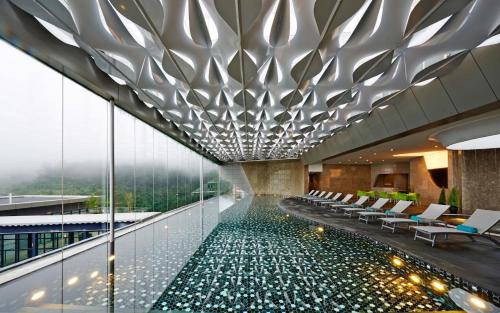 una piscina al centro di un edificio con sedie di The ECON at Genting Highlands a Resorts World Genting