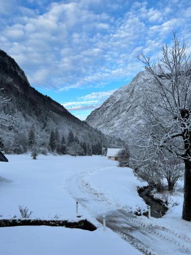 a road covered in snow with a mountain in the background at Apartments Mala Korita Soče in Soča