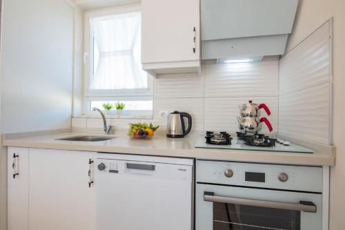 a white kitchen with a stove and a sink at SunTeos Villa Suites in Fethiye