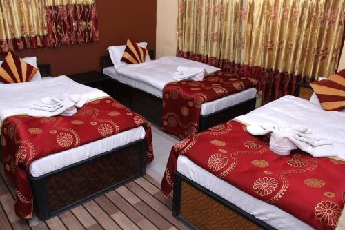 a group of three beds in a room at Elbrus Home in Kathmandu