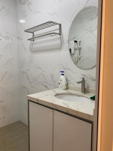 a white bathroom with a sink and a mirror at Lovely 1-Bedroom Condo with Facilities in Malacca