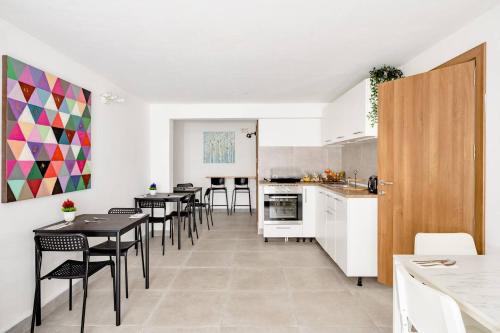 cocina y comedor con mesas y sillas en Casa Leon Malta, en San Julián