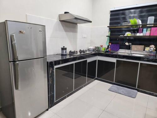 a kitchen with a stainless steel refrigerator at D'Kampung Homestay Melaka in Melaka