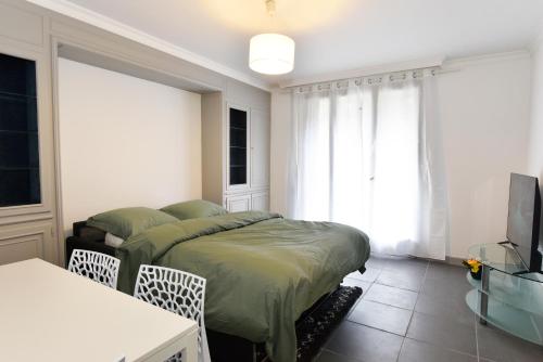 1 dormitorio con 1 cama y TV de pantalla plana en CONFORTABLE T2 AVEC PARKING PRIVE AU CENTRE de BRIVE, en Brive-la-Gaillarde