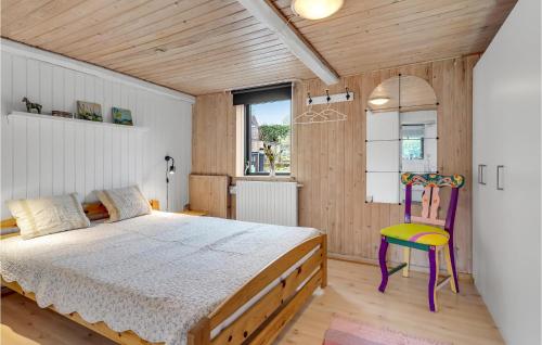 a bedroom with a large bed and a colorful chair at Beautiful Home In Hadsund With Wifi And 3 Bedrooms in Hadsund