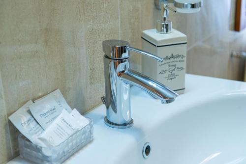 - un lavabo avec robinet et une bouteille de savon dans l'établissement B&B Da Nina Venice, à Venise